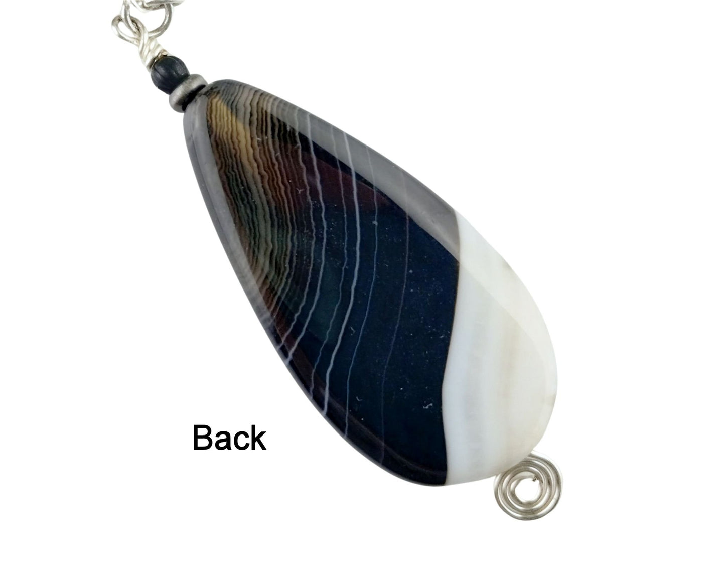 Close-up of black and white agate pendant on glass beaded chain