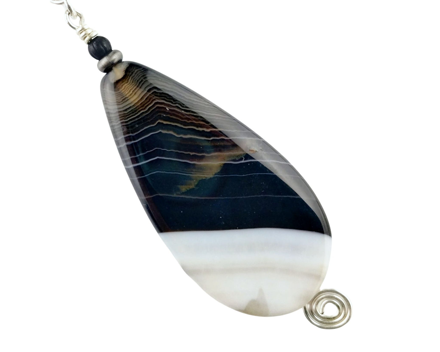 Close-up of black and white agate pendant on glass beaded chain