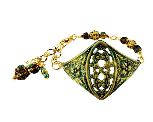 Handmade floral filigree bracelet with green glass beads and brass centerpiece.