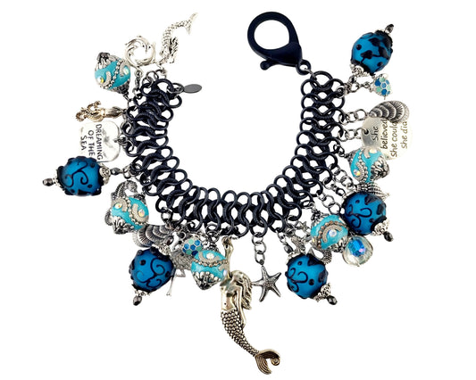Black and blue charm bracelet with various beads and a clasp on a white background