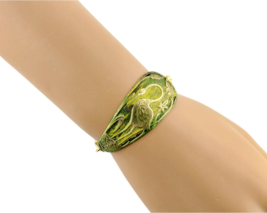 Green bracelet on a mannequin arm with a white background