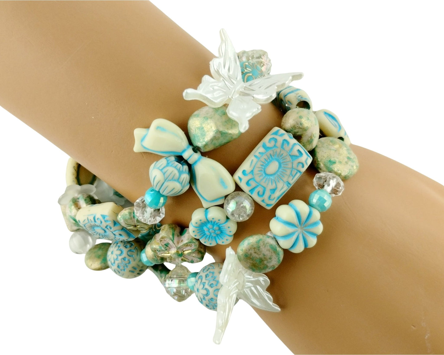 Turquoise and white beaded bracelet with decorative elements on a wrist against a white background