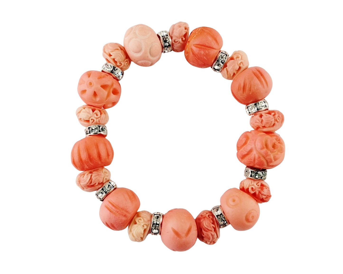 A beaded stretch bracelet made of carved coral beads in shades of orange and pink, separated by small silver-toned spacer beads, shown on a plain white background.