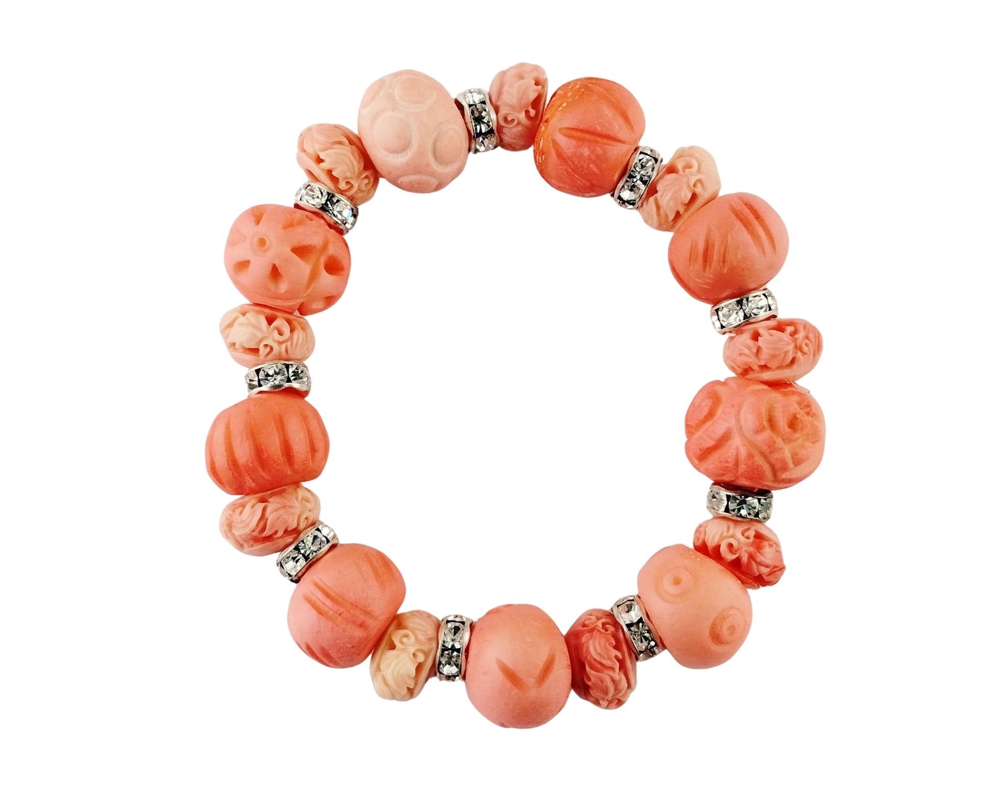 A beaded stretch bracelet made of carved coral beads in shades of orange and pink, separated by small silver-toned spacer beads, shown on a plain white background.