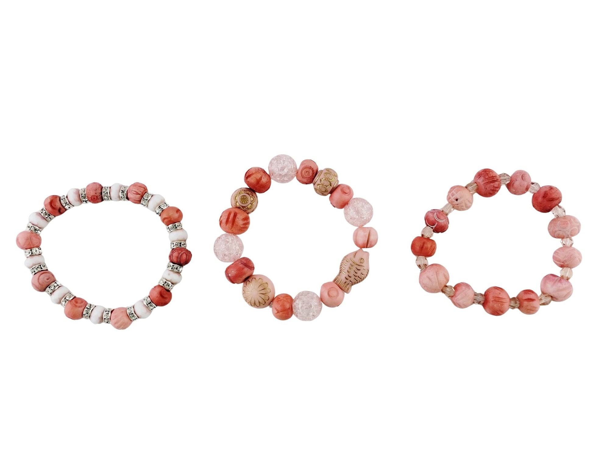 Three beaded stretch bracelets arranged side by side on a plain white background. The bracelets feature round beads in shades of coral pink, terracotta red, and light beige, accented with small metallic silver spacer beads.