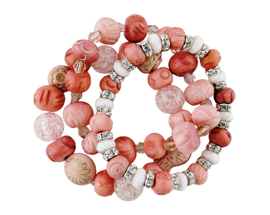 A set of three beaded stretch bracelets featuring pink, coral, and white beads with silver rhinestone accents, displayed on a clean white background.