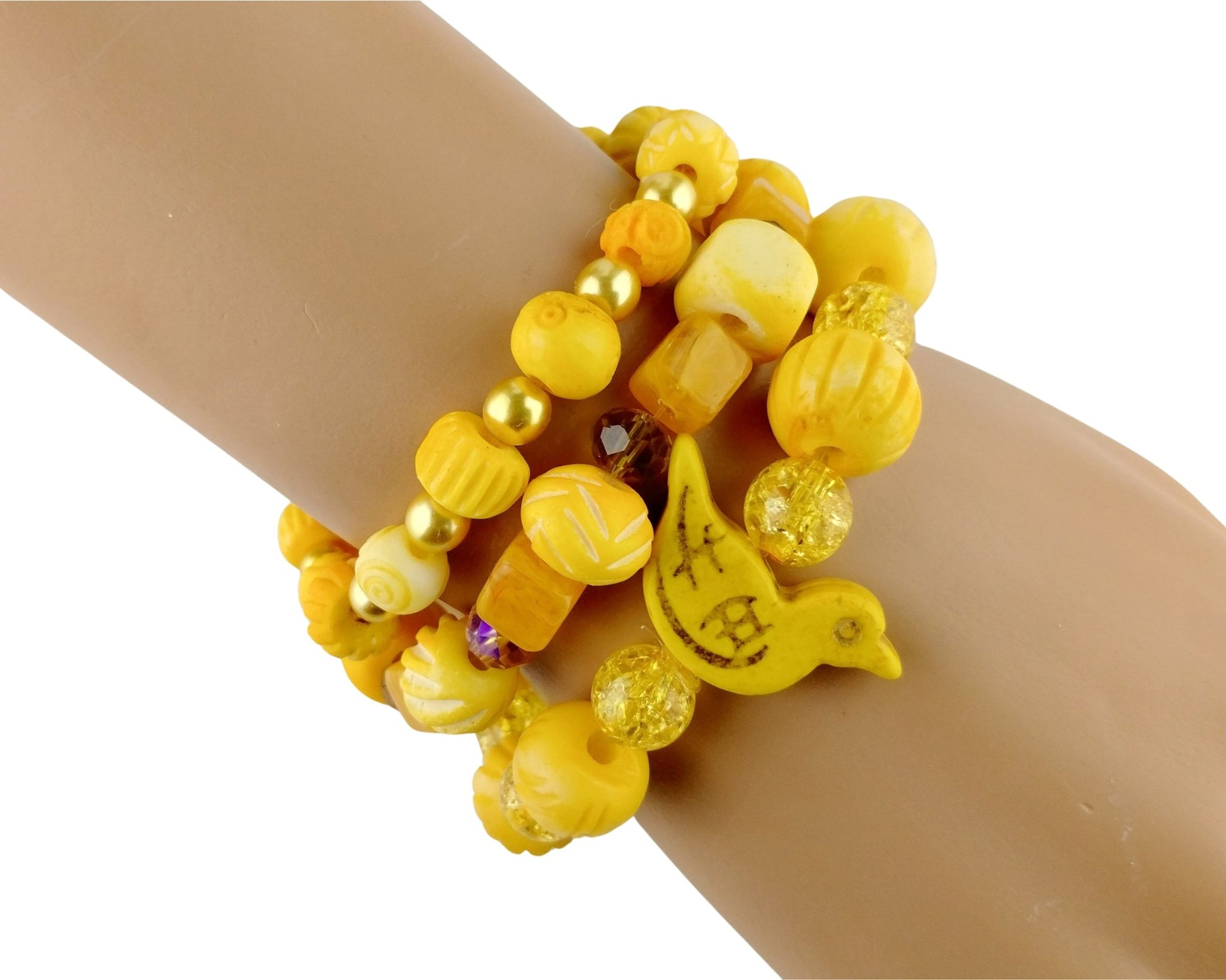 A stack of yellow beaded bracelets with a small yellow bird charm, shown worn on a mannequin wrist against a white background.