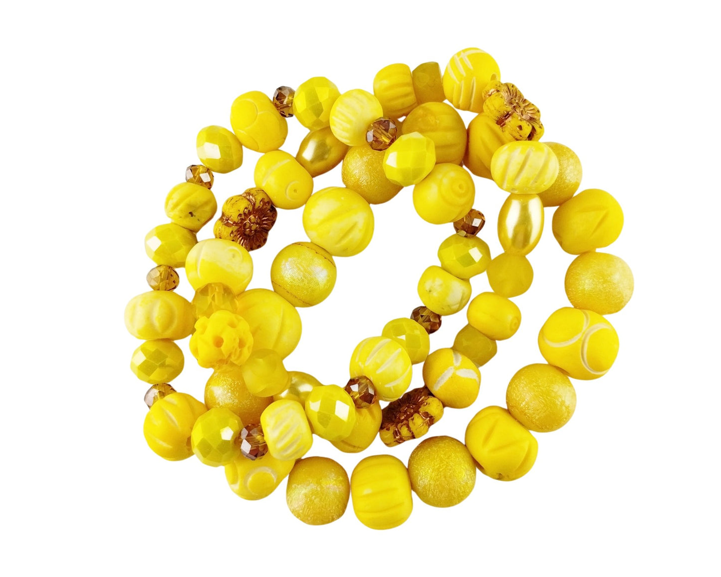 A coiled strand of yellow beads with various textures, including smooth matte, glossy, and carved details, accented with a few small brown beads, isolated on a white background.