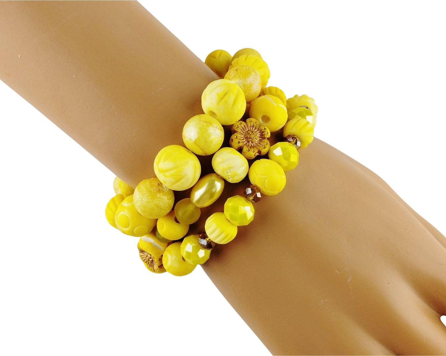 A stack of yellow beaded bracelets worn on a mannequin wrist against a plain white background.