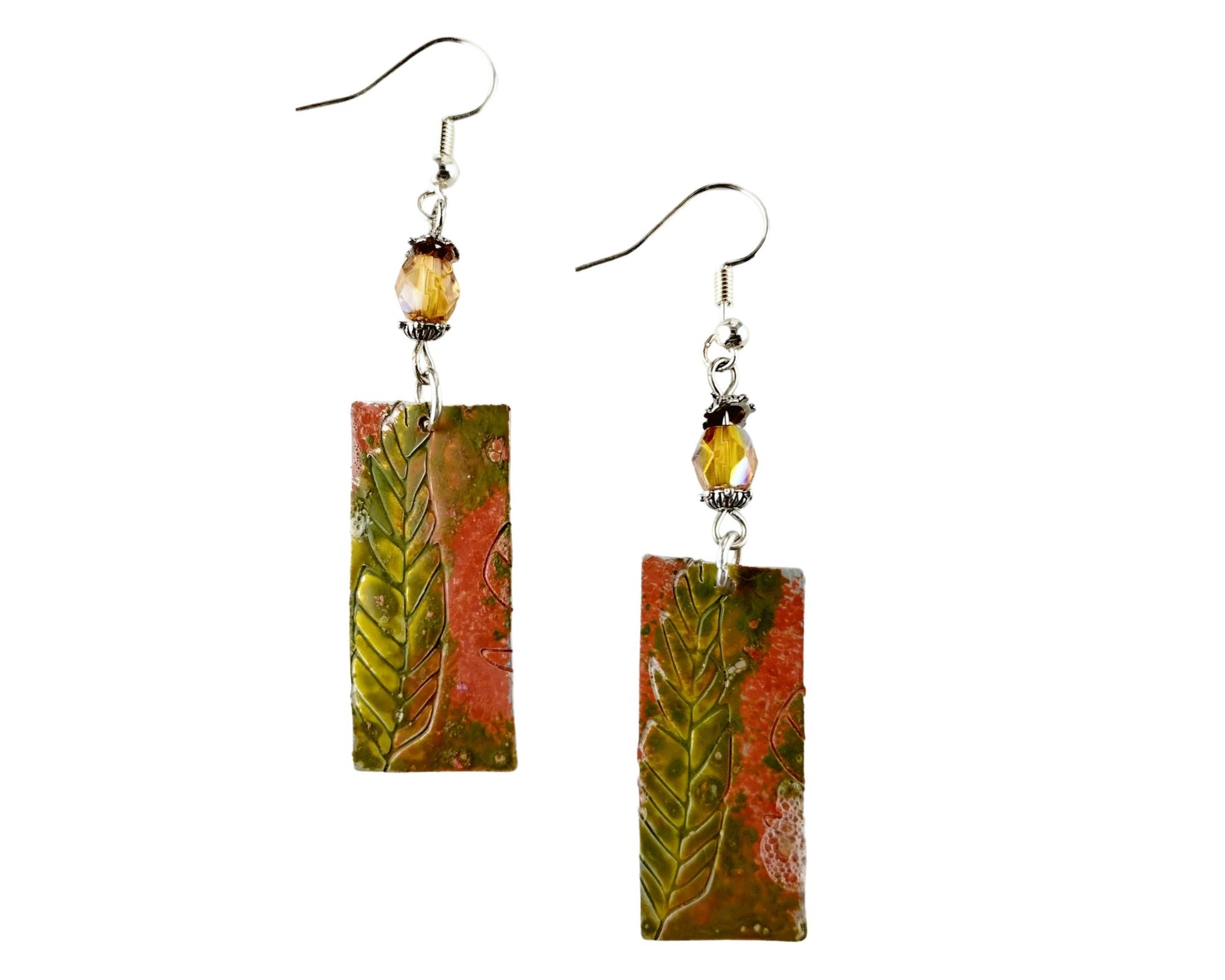 Hand-painted pewter fern earrings with amber pink glass beads on white background