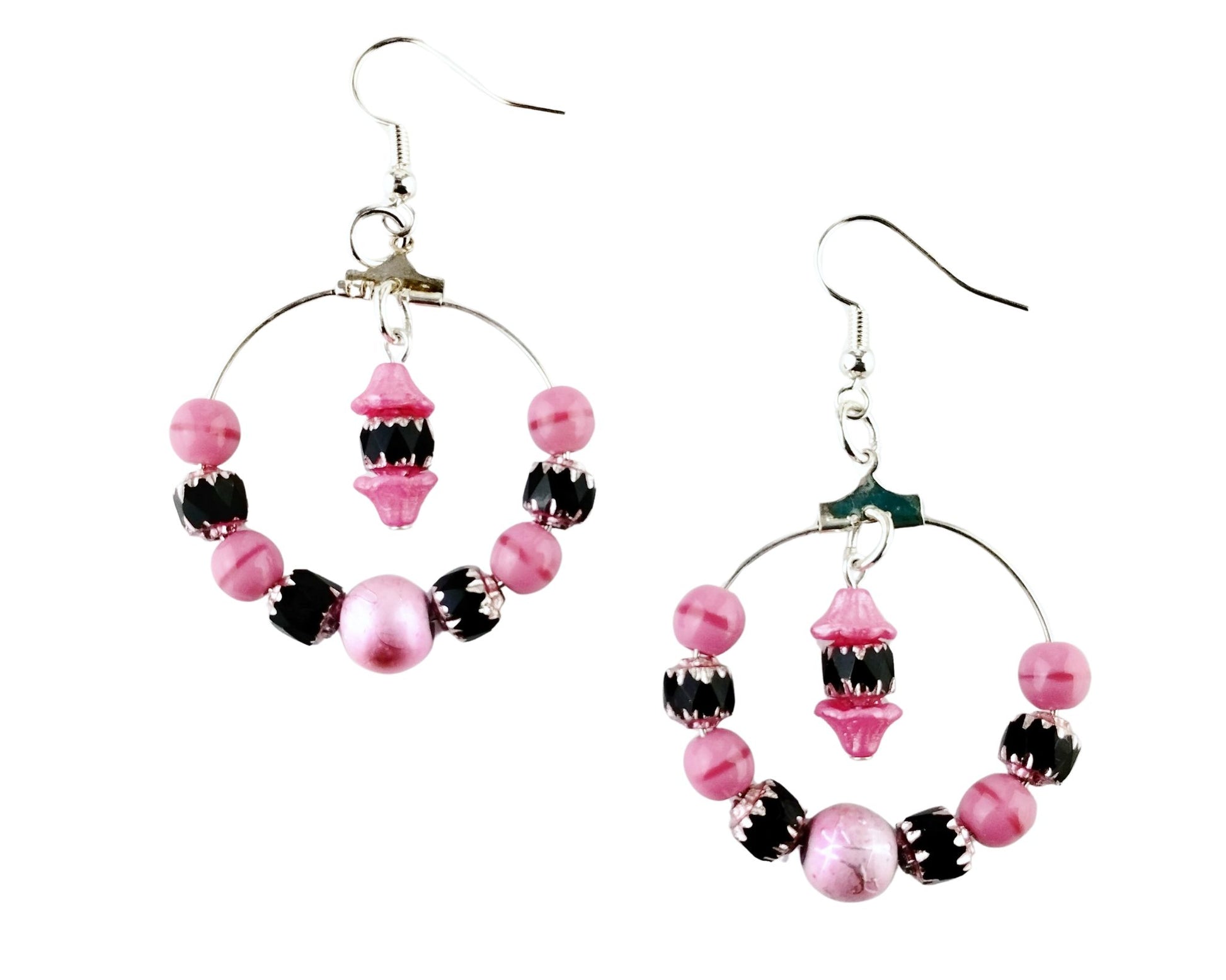 Pink flower-capped bead drop earrings with black glass center and silver hoop.

