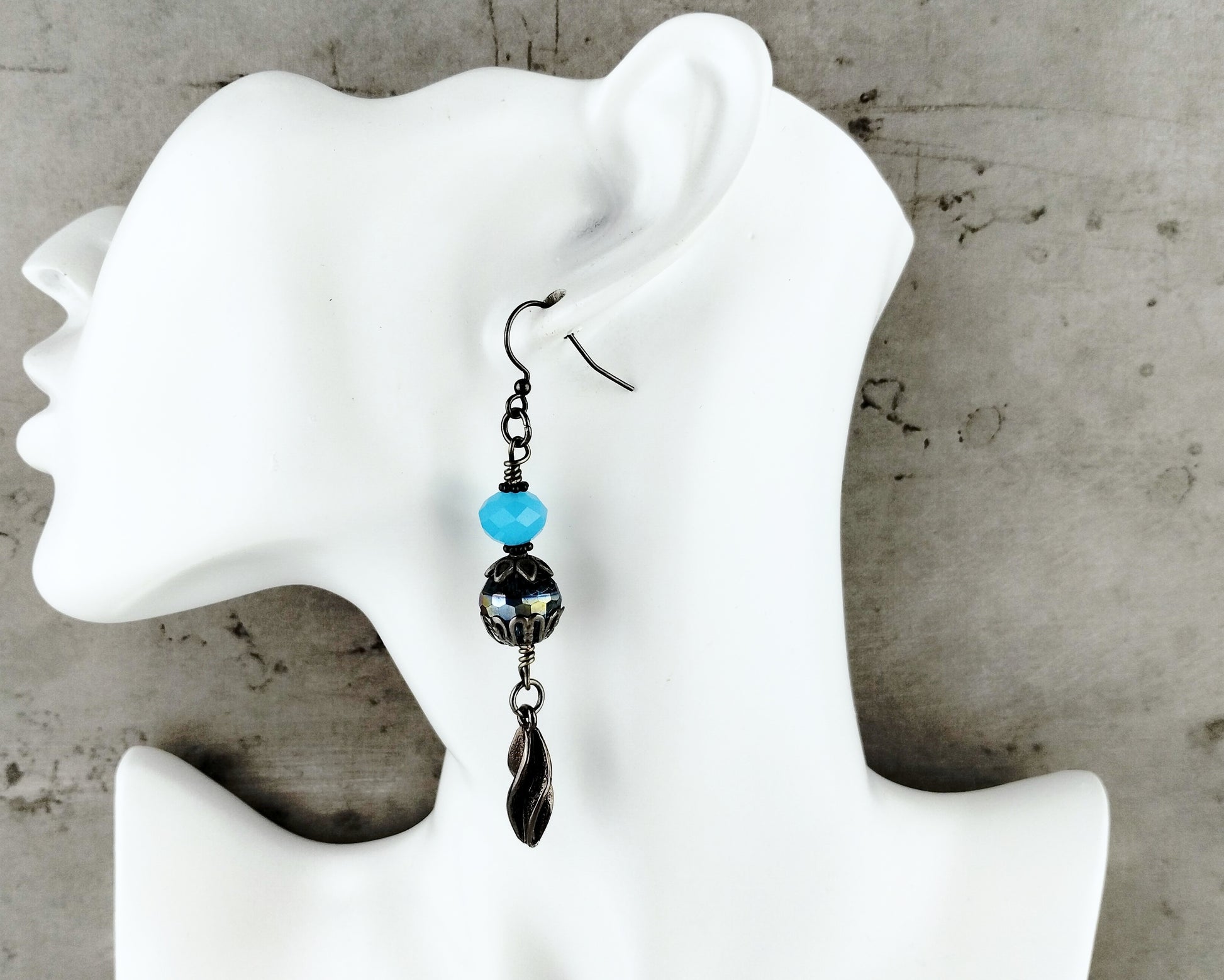 Handmade earrings featuring aqua blue glass beads with twisted gunmetal black chain and nickel-free ear wires