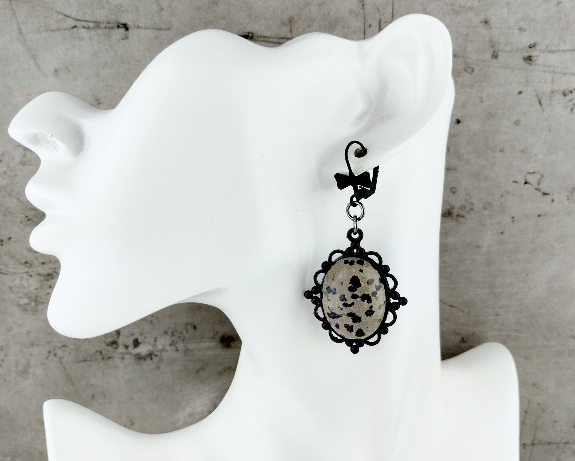 Statement earrings featuring natural spotted stone and dark setting