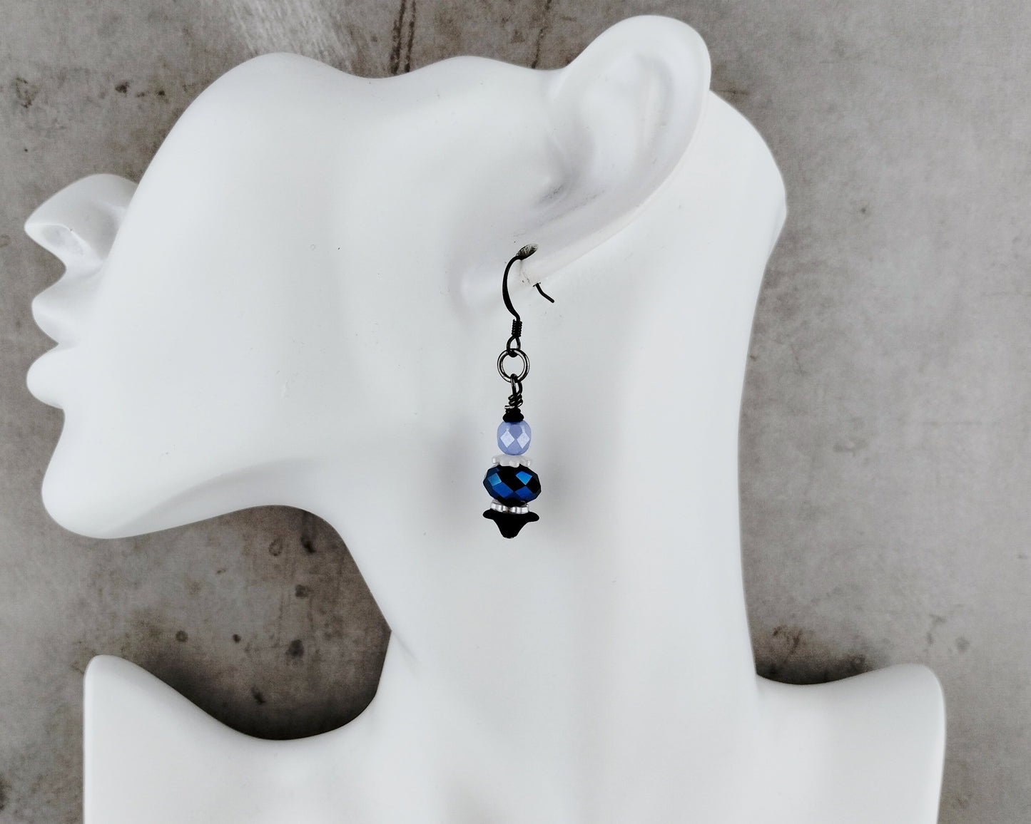 Earring displayed on a white mannequin ear with a gray background