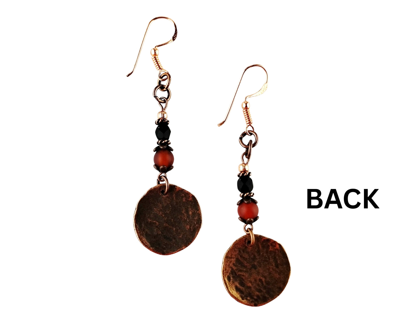 Pair of earrings with circular copper-like discs and orange and black beads on a white background.