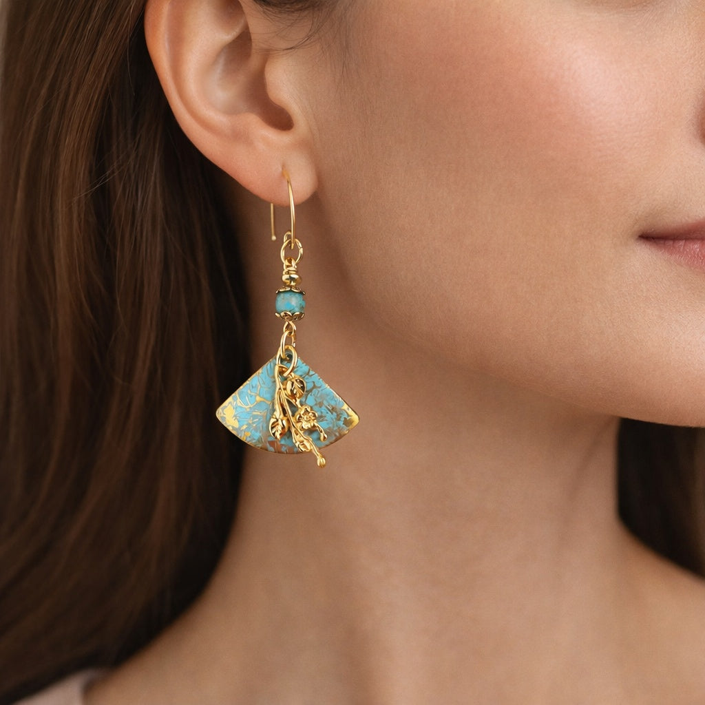 Close-up of a woman wearing a gold and turquoise earring.