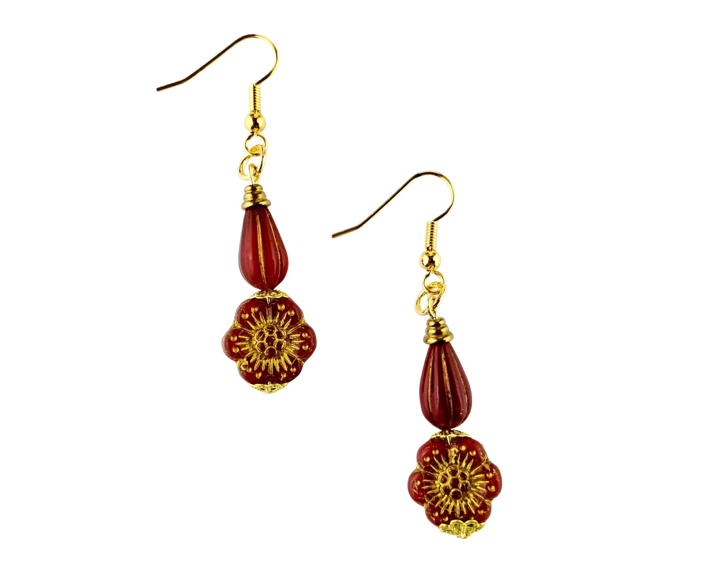Pair of red beaded earrings with gold floral designs on a white background