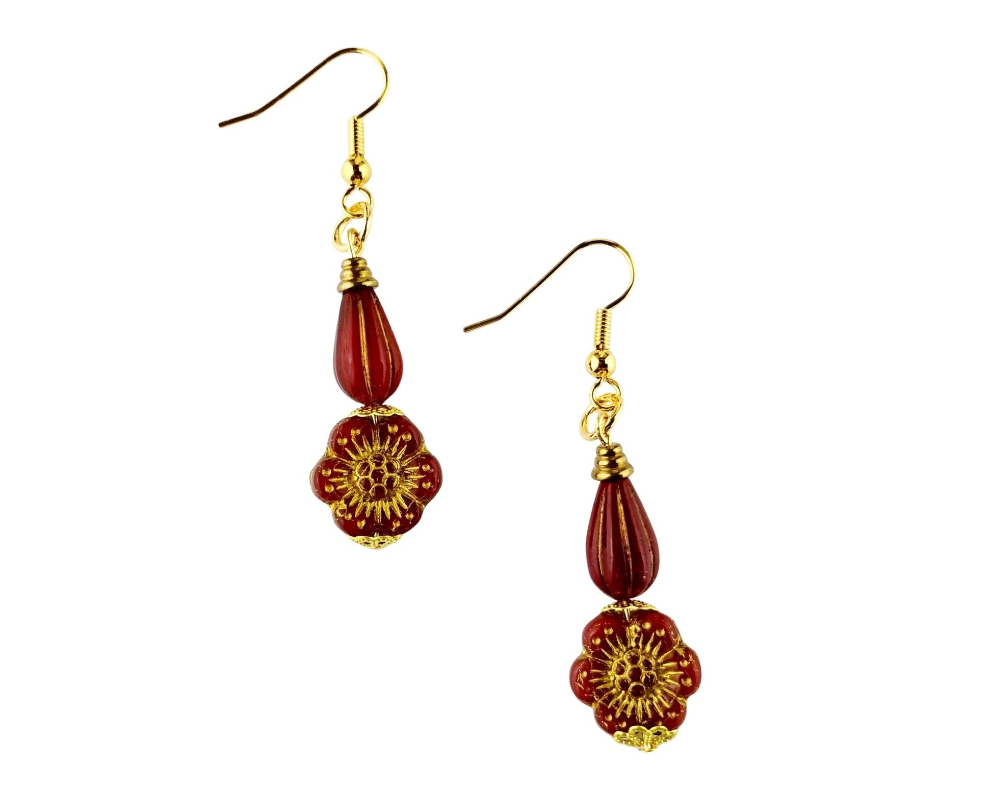 Pair of red beaded earrings with gold floral designs on a white background
