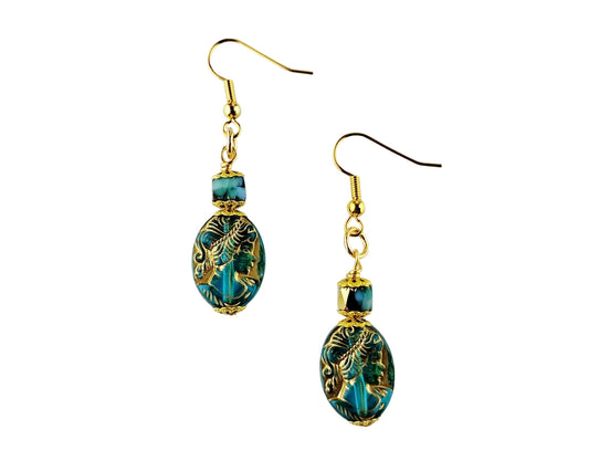 Pair of earrings with gold and blue beads on a white background