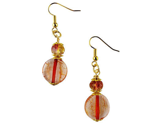 Pair of earrings with orange and gold beads on a white background