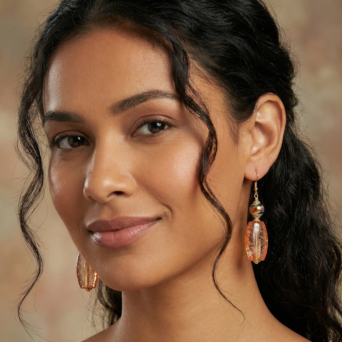 Close-up of a woman wearing gold earrings with a blurred background