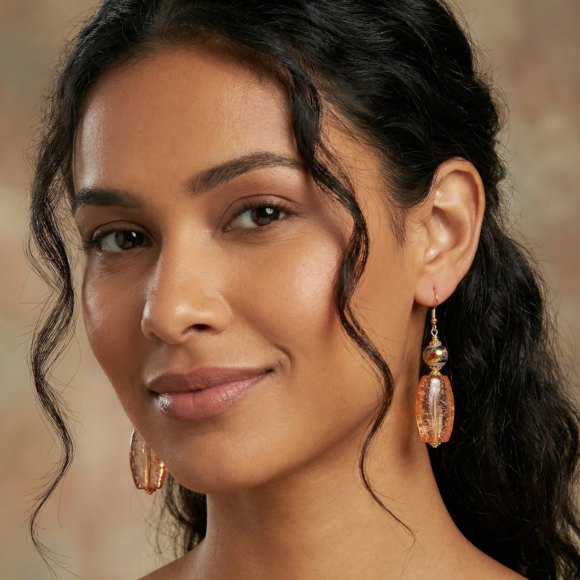Close-up of a woman wearing gold earrings with a blurred background