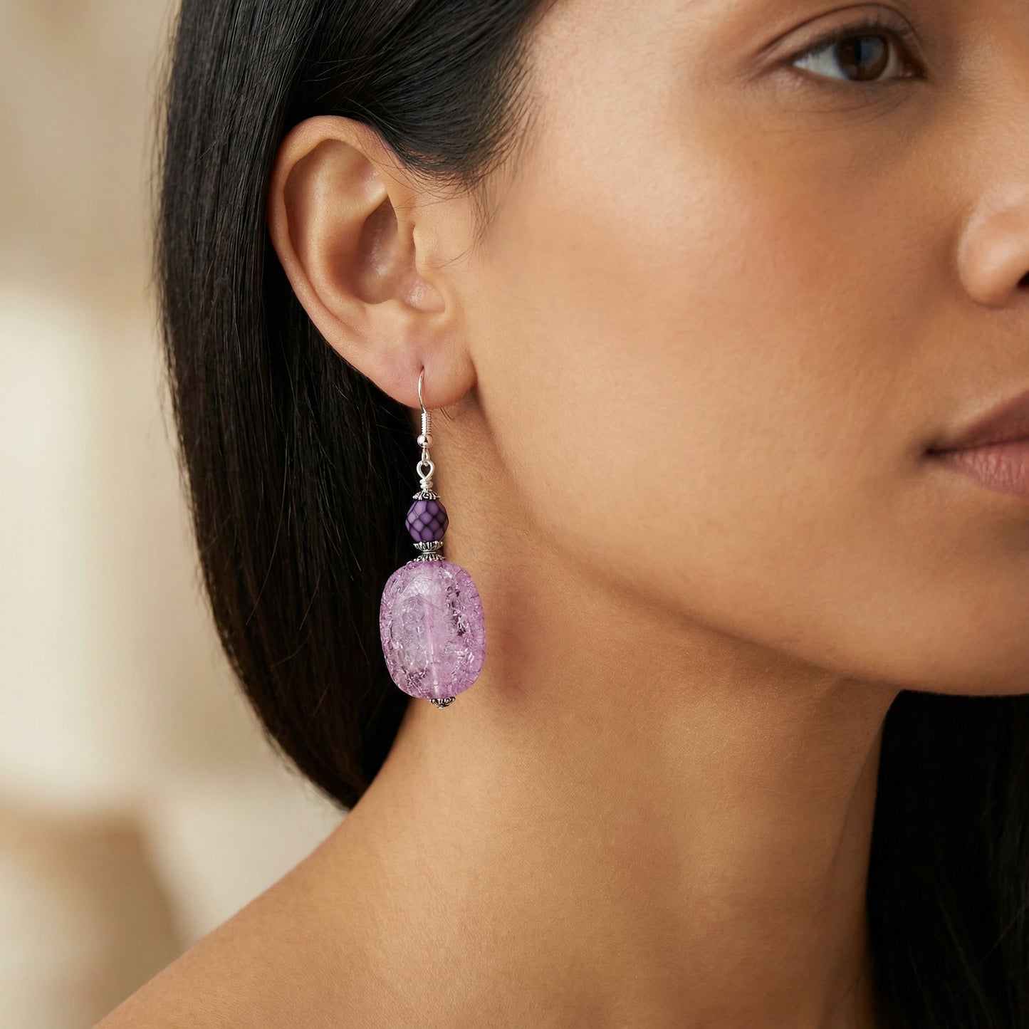 Close-up of a woman wearing a purple earring with a blurred background
