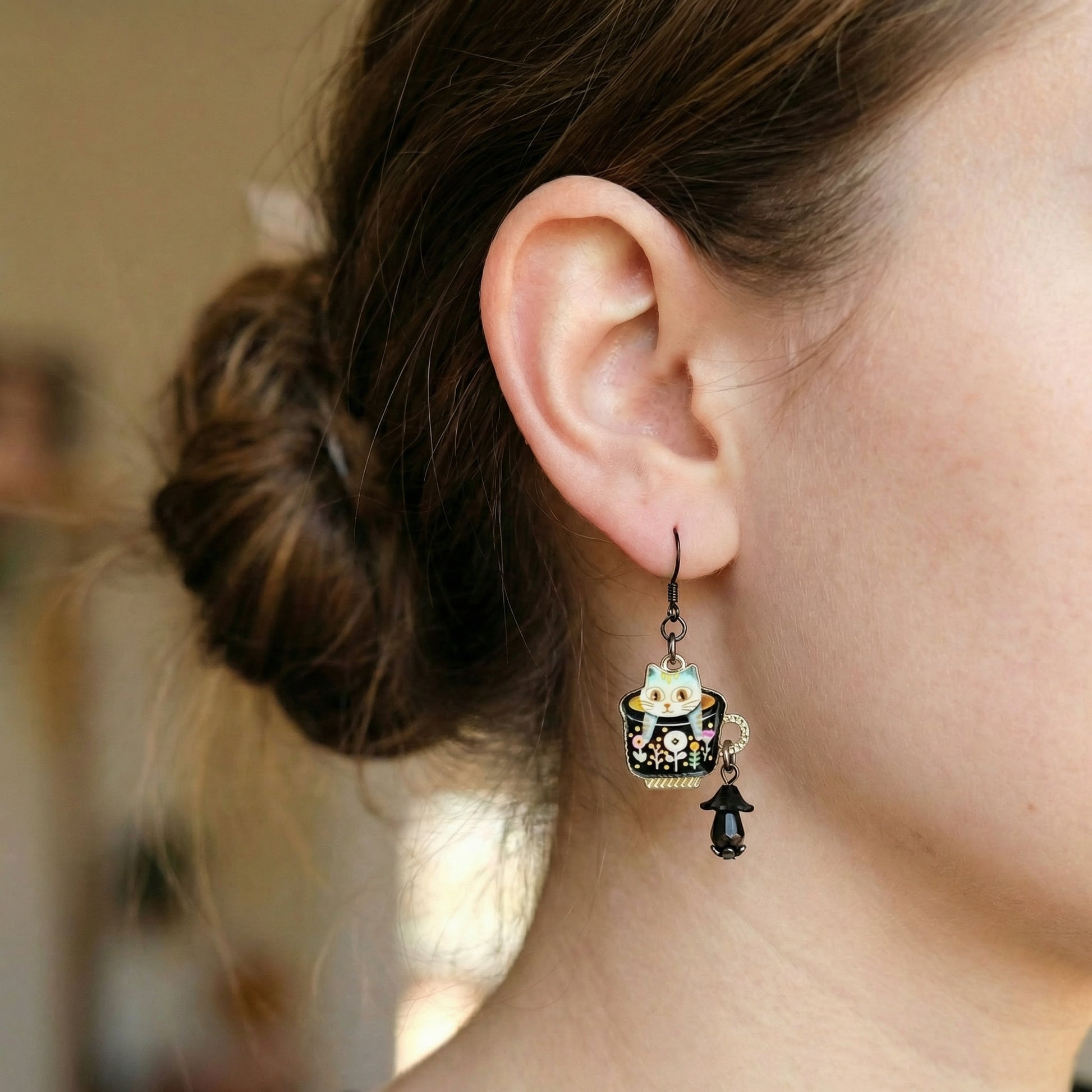 Close-up of an ear wearing a decorative earring with a blurred background