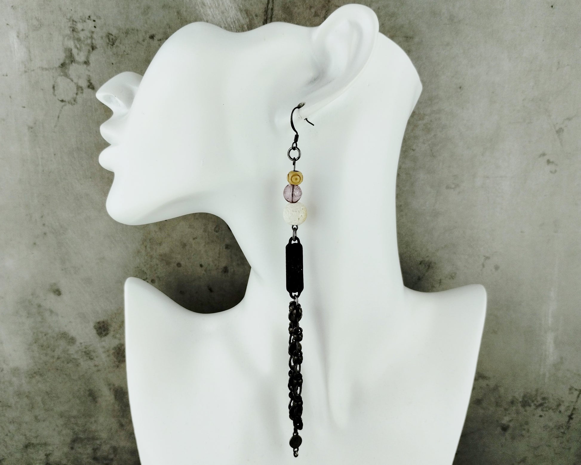 Long earrings on a white mannequin. 