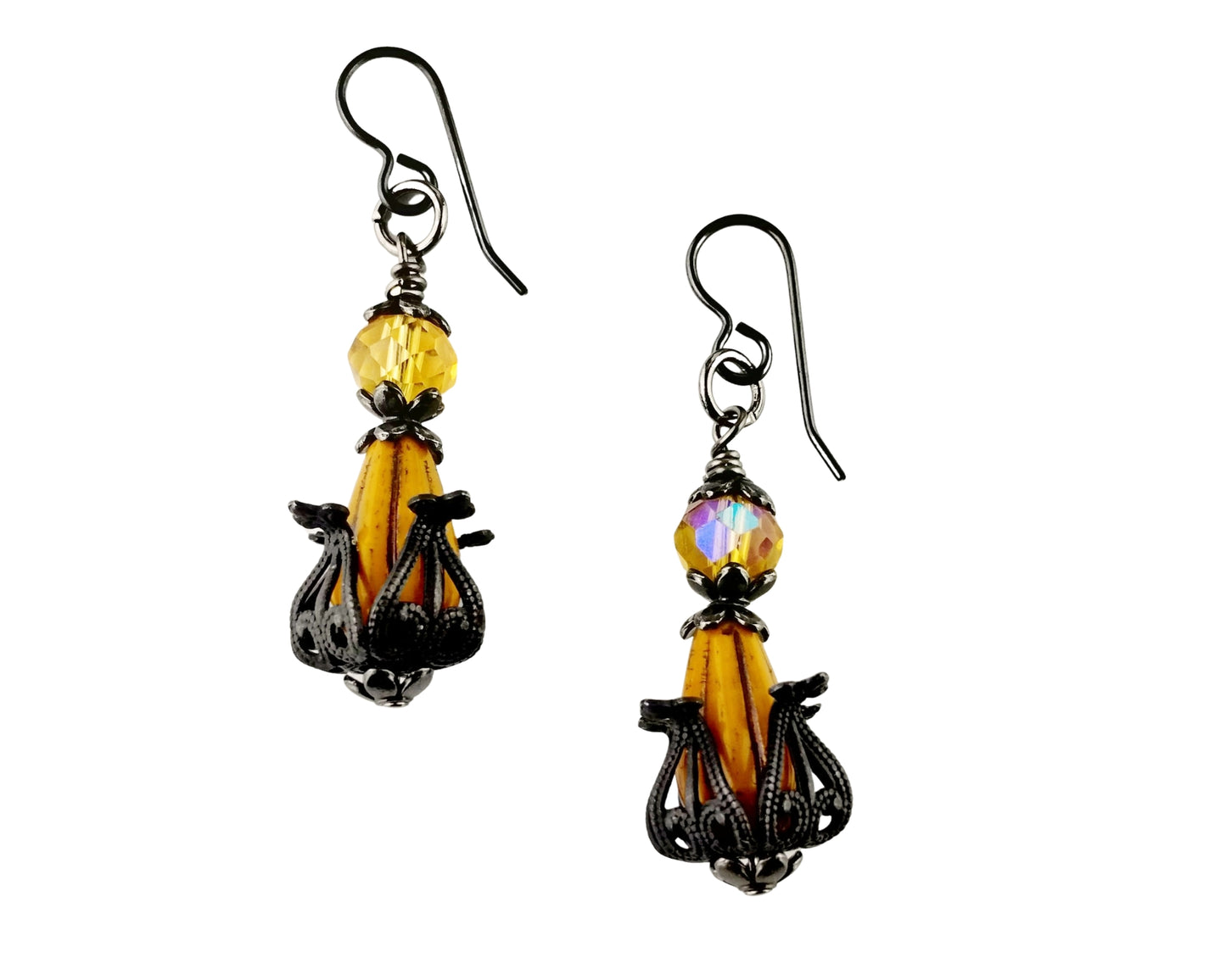 Pair of earrings with yellow and black designs on a white background