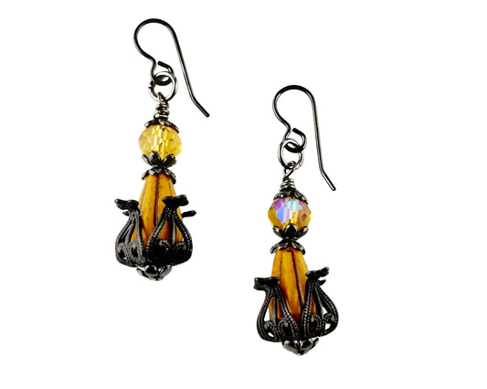 Pair of earrings with yellow and black designs on a white background