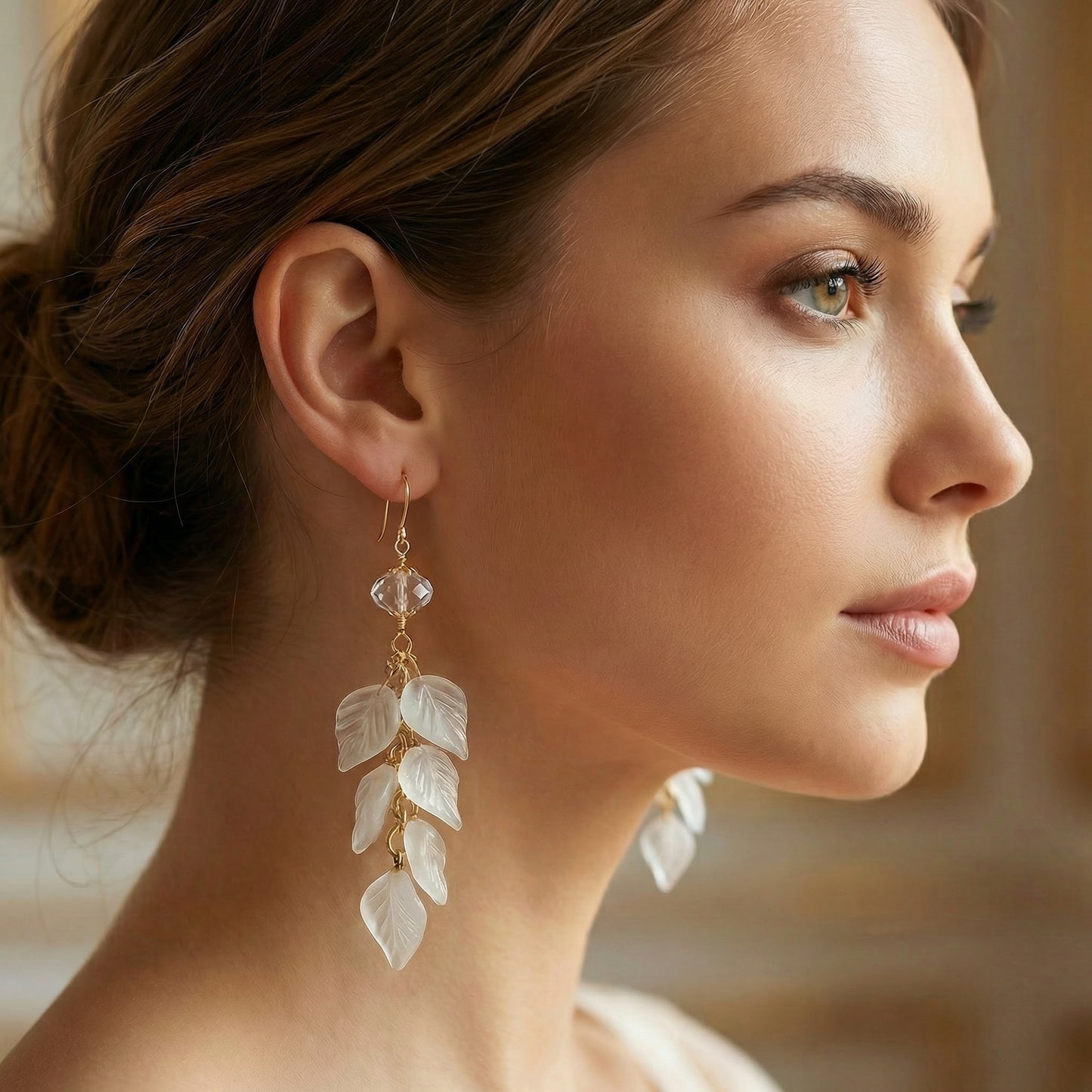 Close-up of a woman wearing elegant leaf-shaped earrings with a blurred background