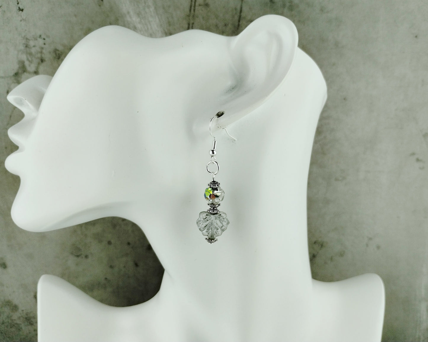 Earring displayed on a white mannequin ear with a gray background