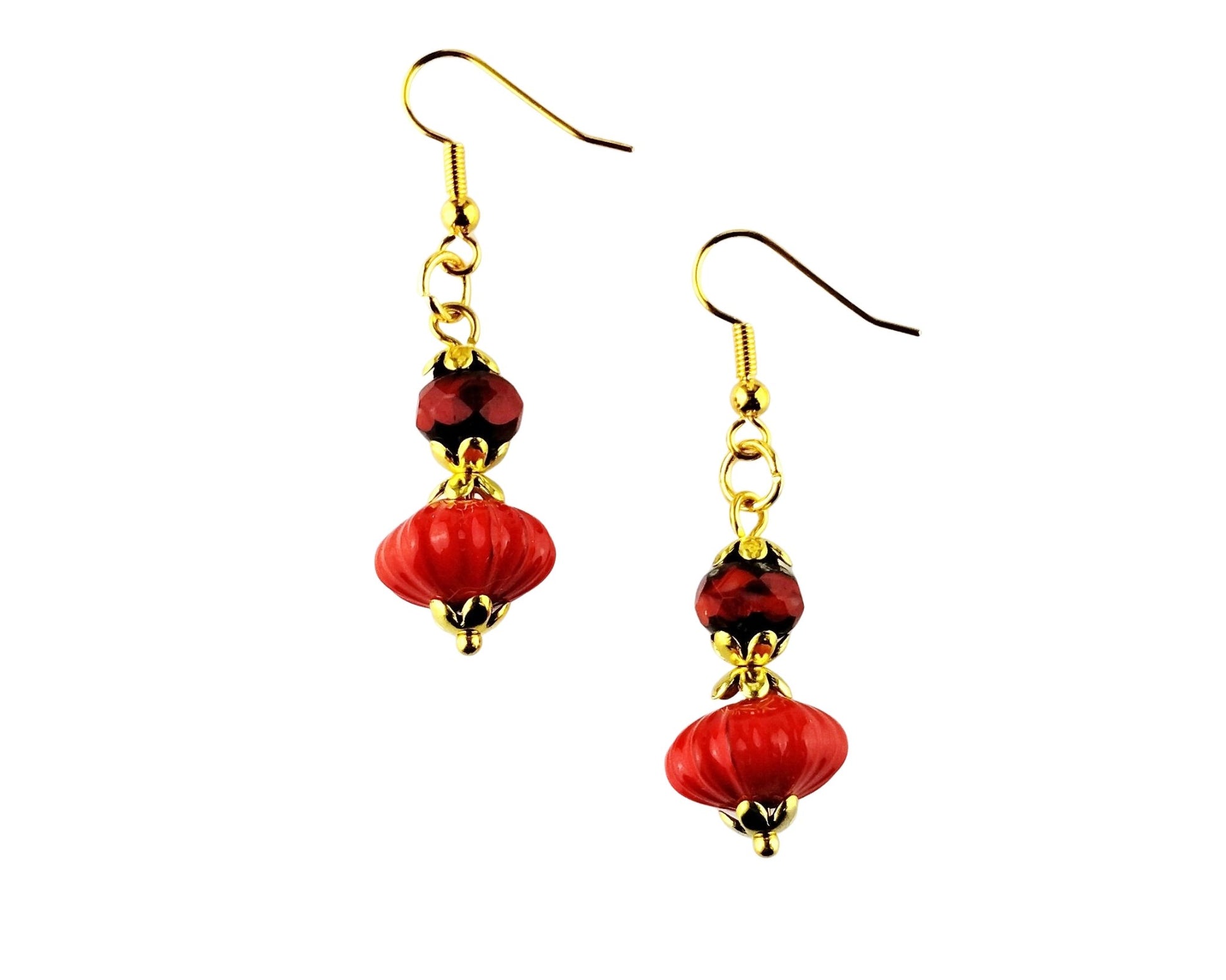 A pair of dangling earrings with gold-tone fishhook wires, small faceted dark red beads, and larger glossy red bead drops with gold-tone caps, shown on a plain white background.