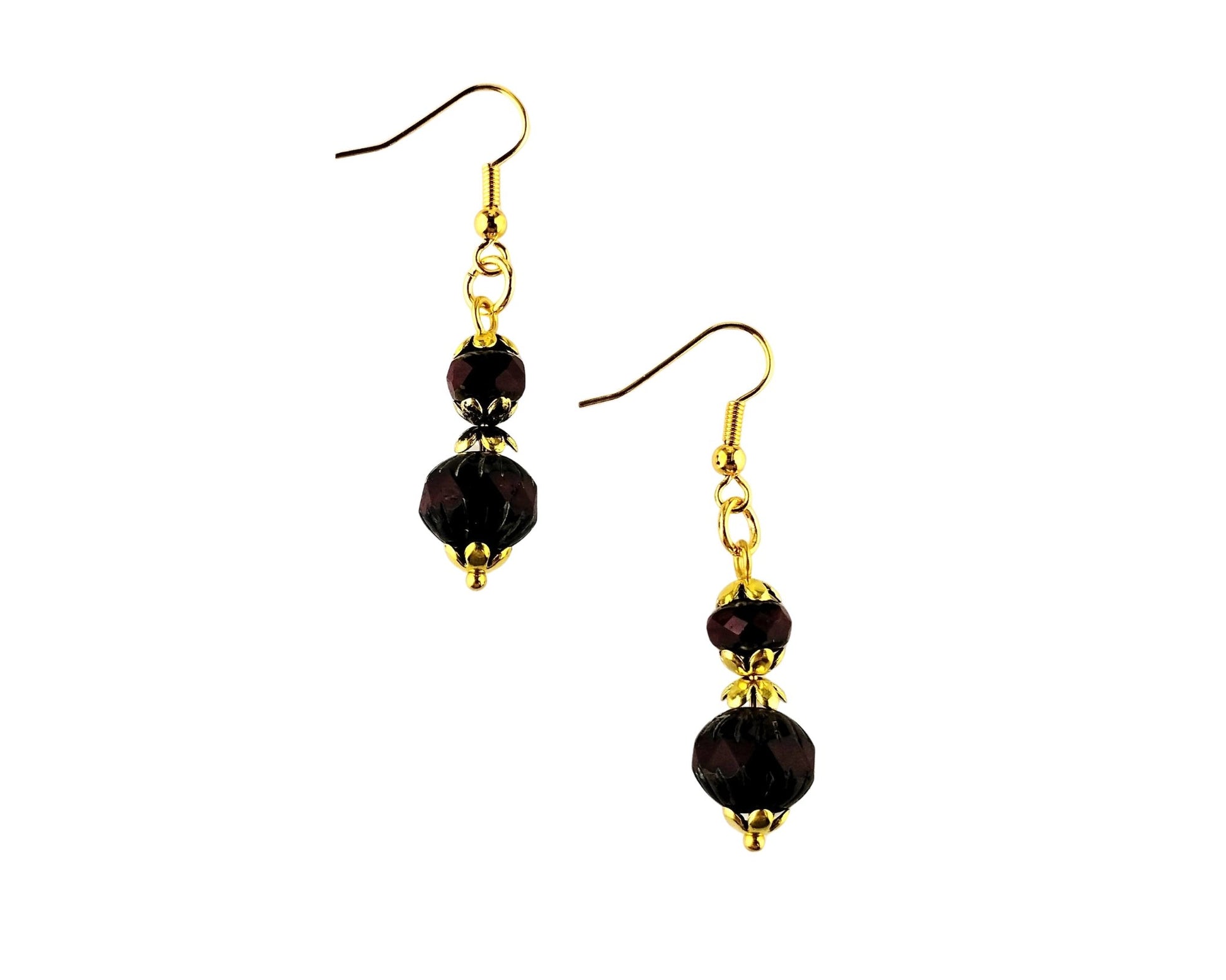 A pair of gold-tone dangle earrings with faceted dark red beads, shown against a plain white background.