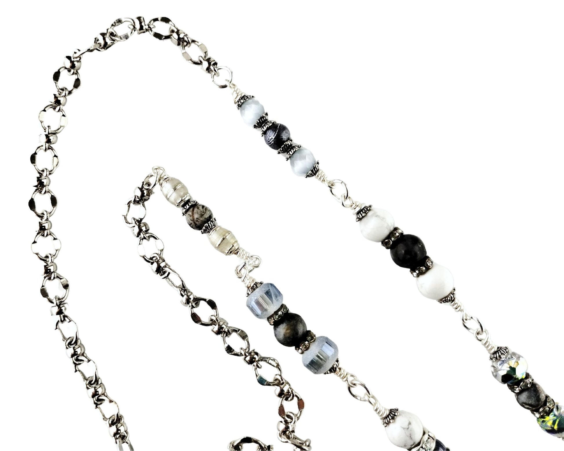 Close-up of white glass cat’s eye pendant with silver tassel and gray bead chain.