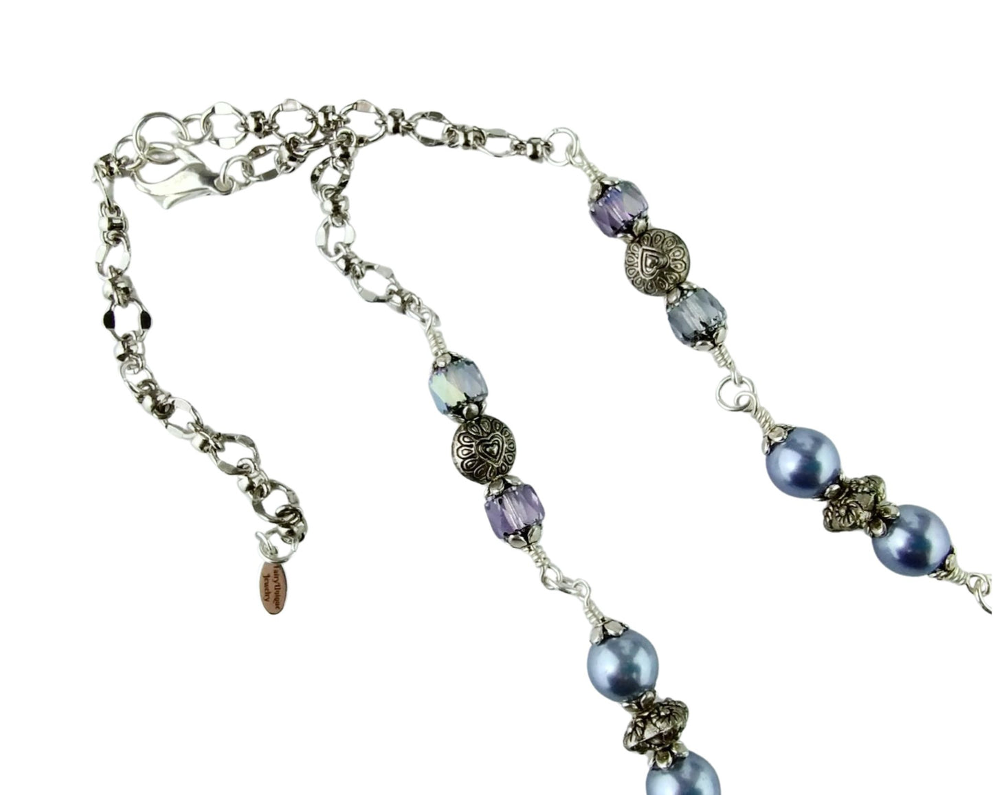 Close-up of handmade fairy cabochon pendant framed in silver with magical accents.