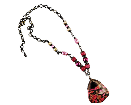Handmade magenta pink jasper shield necklace with pearl and glass bead accents.