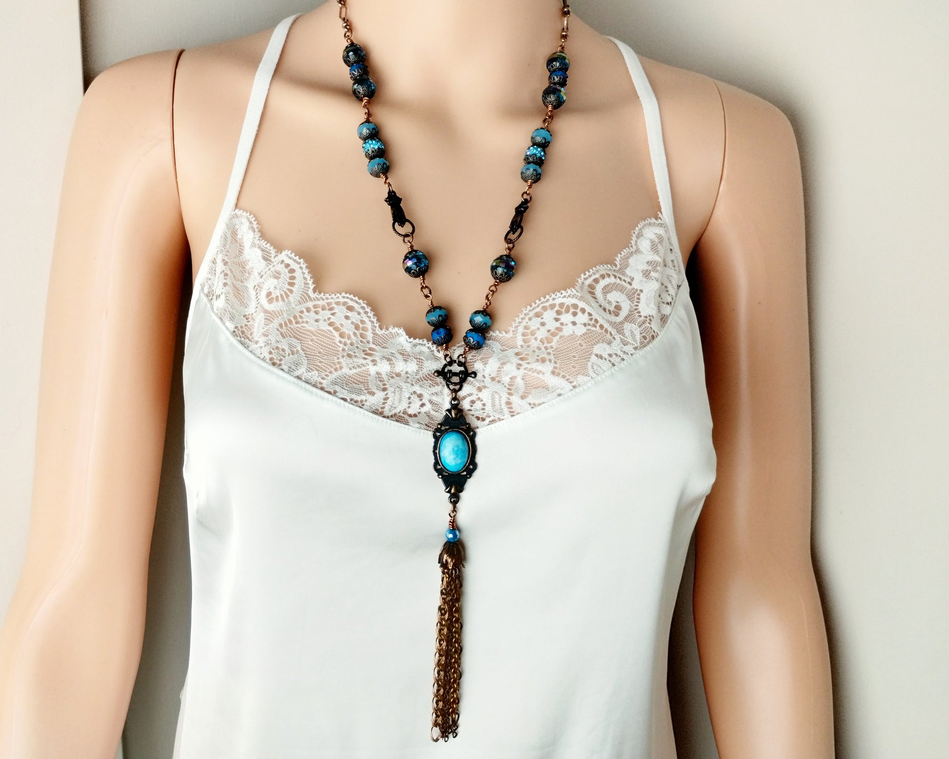 Vintage-inspired necklace with opaque aqua cabochon and flower cap tassel