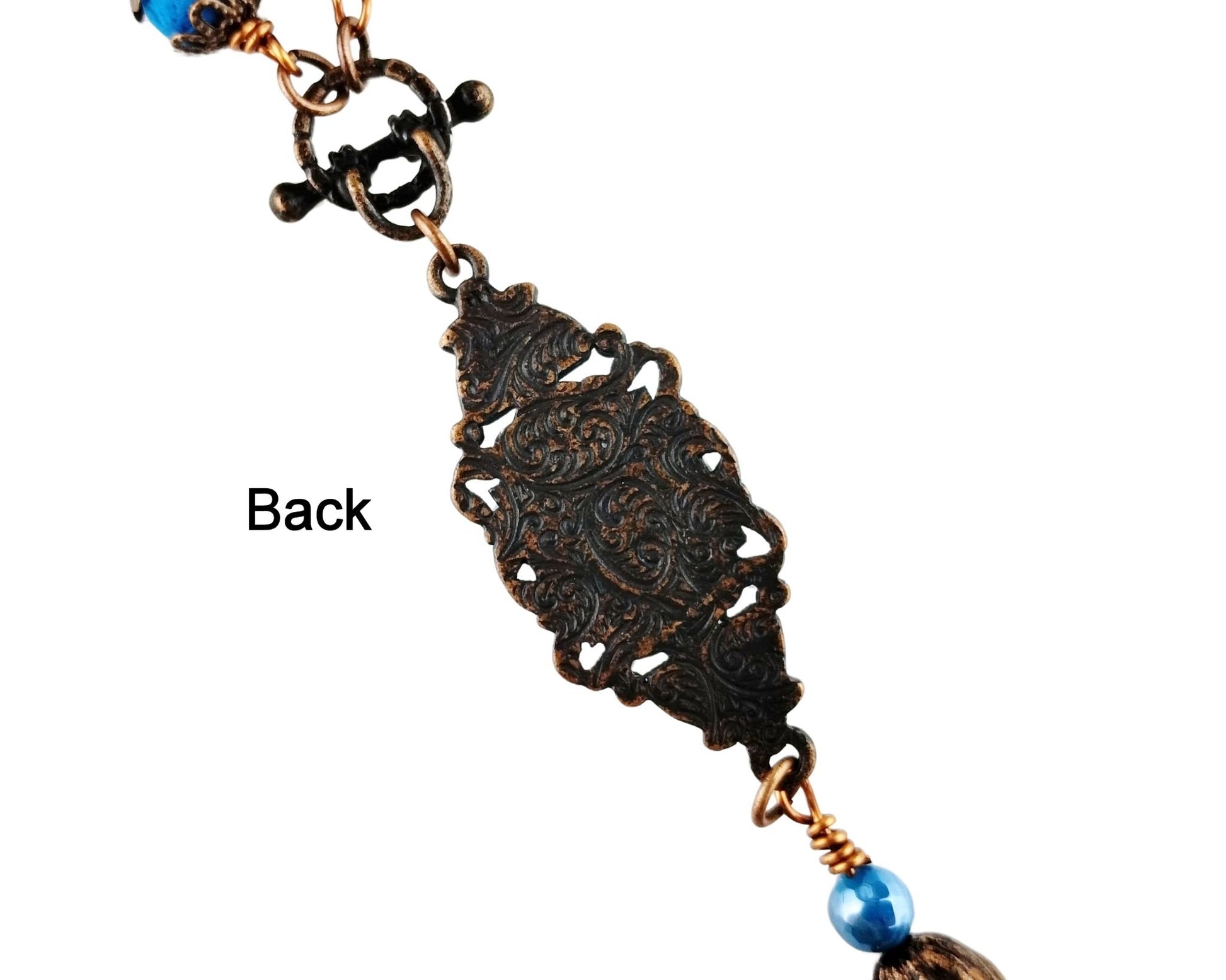 Vintage-inspired necklace with opaque aqua cabochon and flower cap tassel