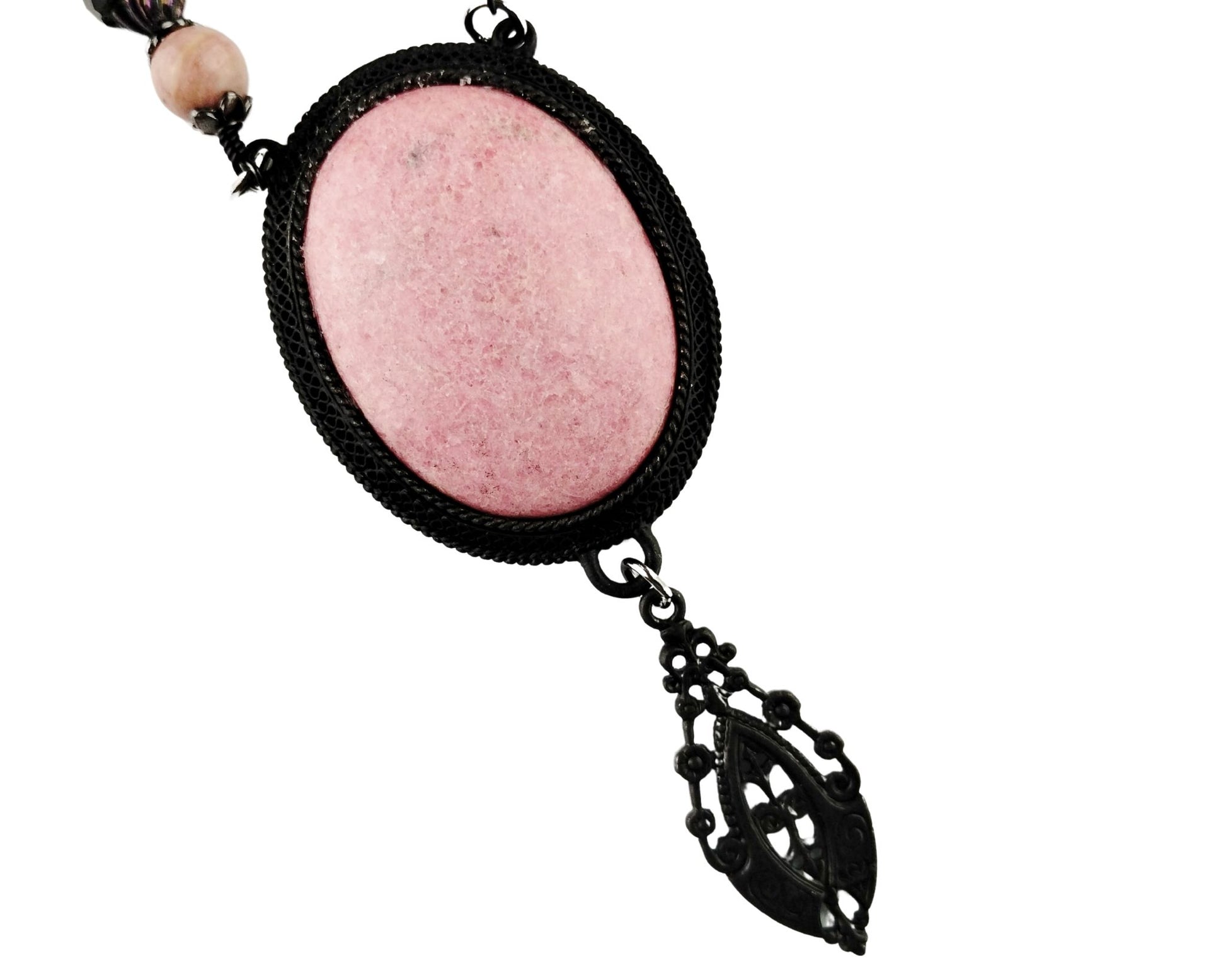 Close-up of large pink rhodonite pendant in matte black bezel