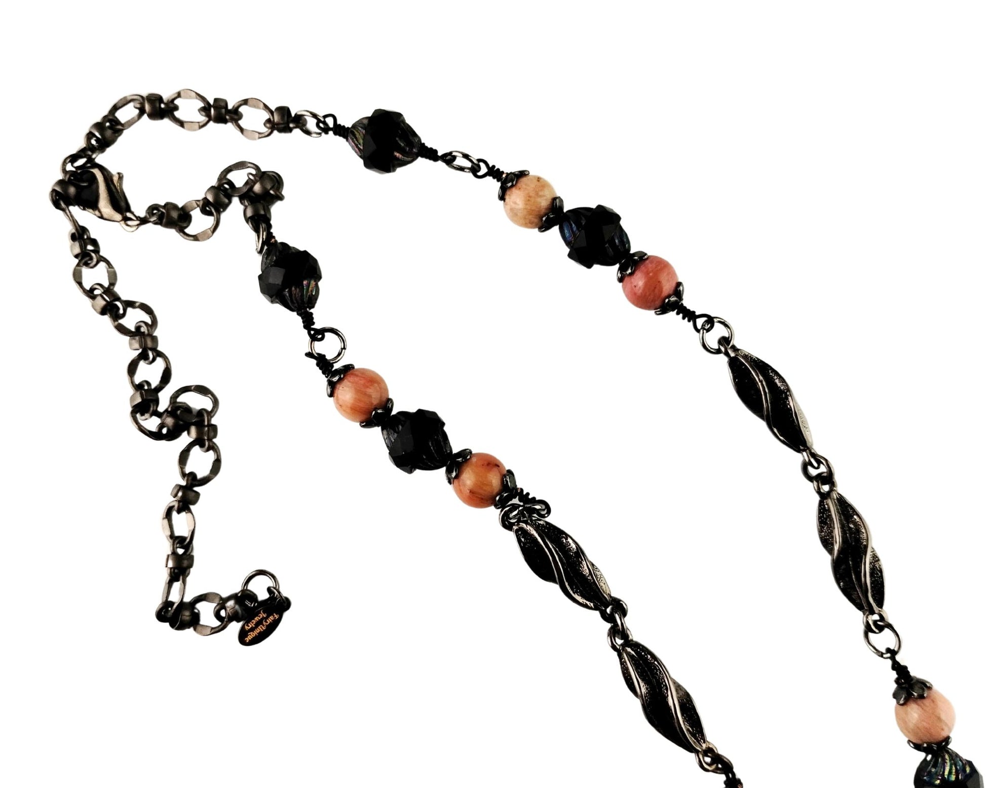 Close-up of large pink rhodonite pendant in matte black bezel