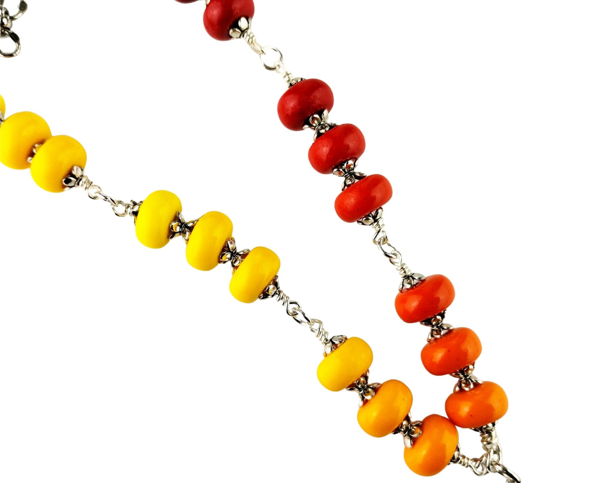 Close-up of bird pendant necklace with red, orange, and yellow bead accents