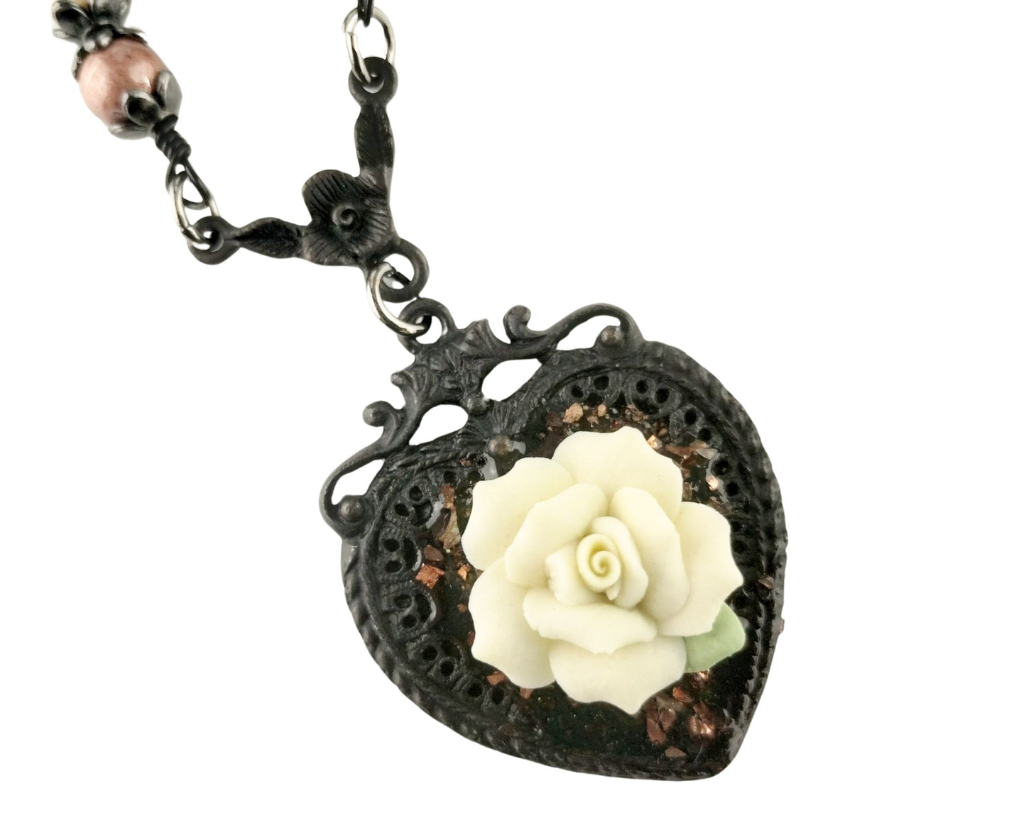 Close-up of heart pendant with brown glitter and floral detail