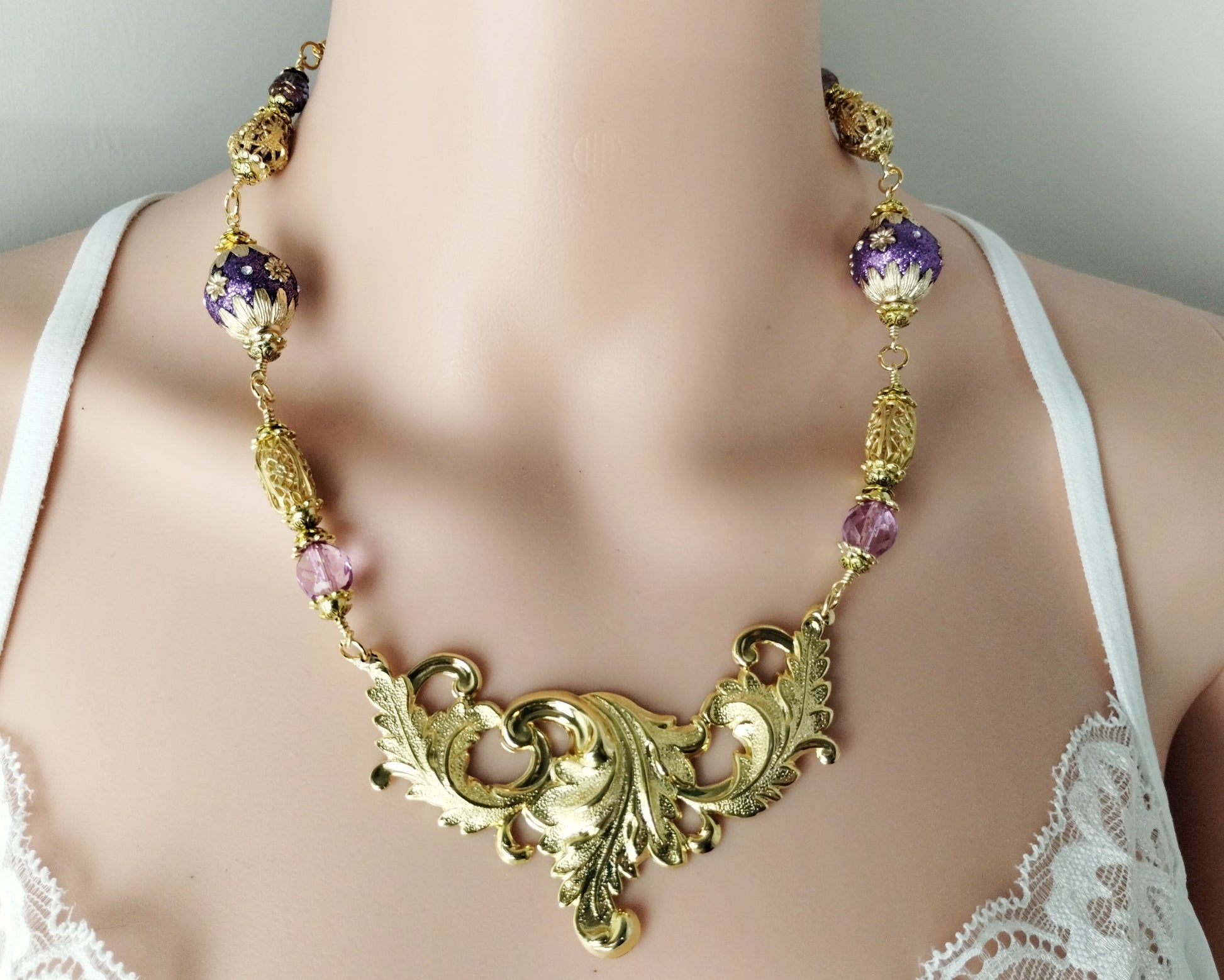 Vintage-inspired gold necklace with botanical swag centerpiece
