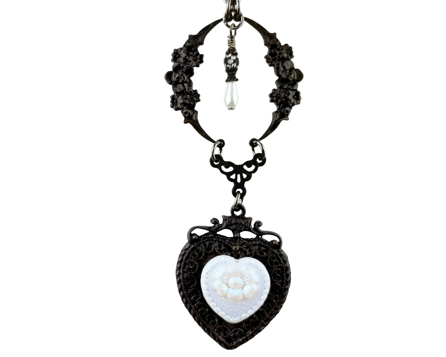 Black filigree necklace with a heart-shaped pendant on a white background