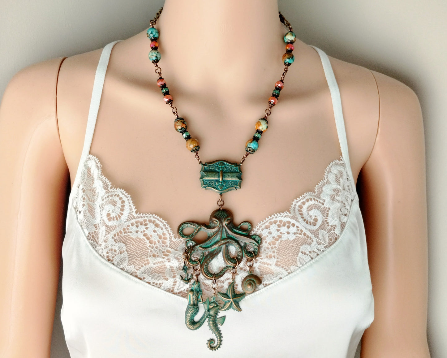 Mannequin wearing a white lace top with a decorative necklace.