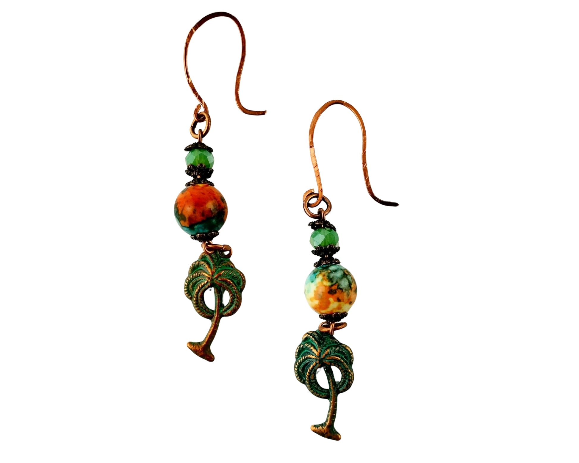 Pair of earrings with green and orange beads on a white background