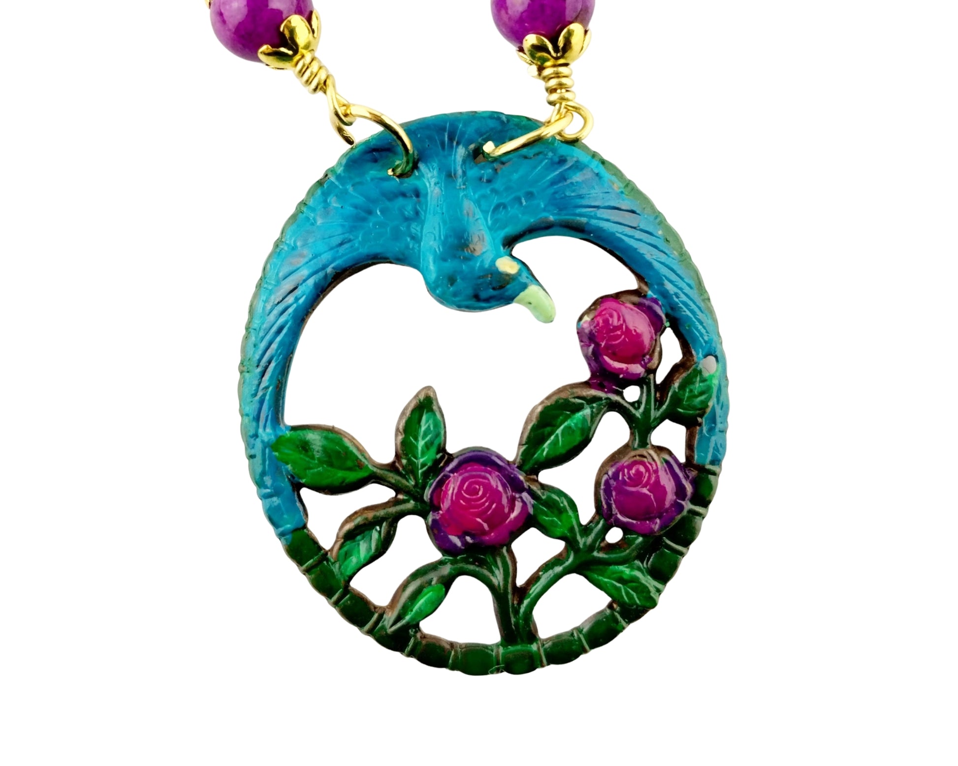 Turquoise pendant with floral design and purple beads on a white background