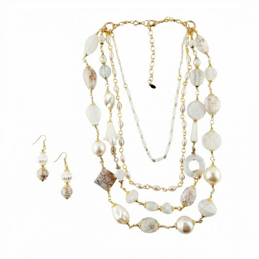 Necklace and earrings set with white beads and gold chain on a white background